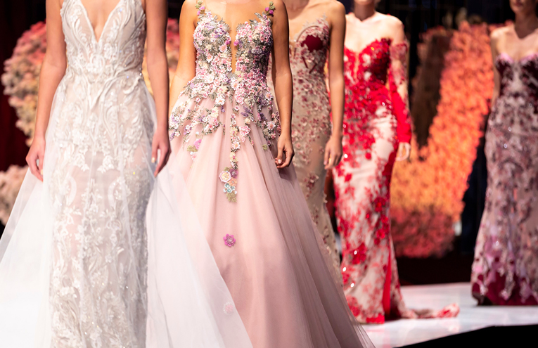 Runway show of vintage ball gowns, preserved through archival fashion storage facility.