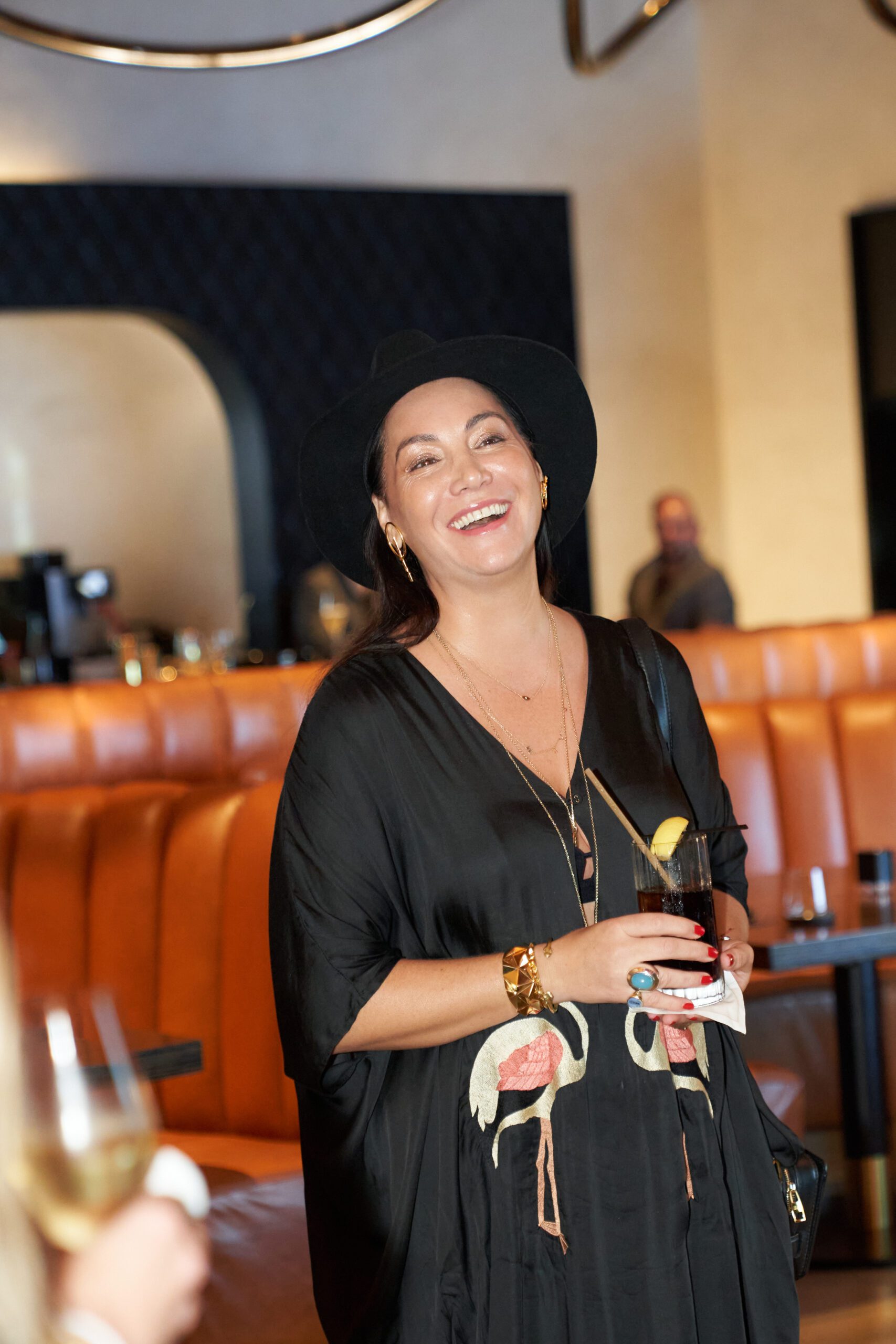 Guest in flamingo-print dress at UOVO x Latin American Fashion Summit dinner event.