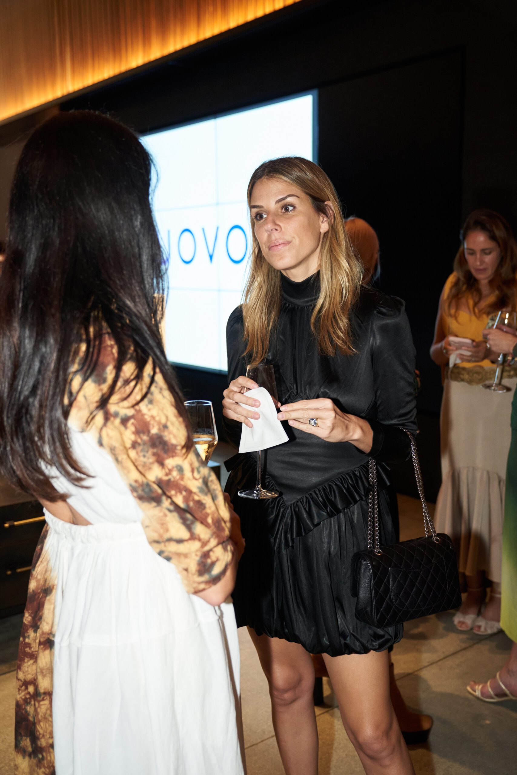 Conversation moments at UOVO x Latin American Fashion Summit dinner, with UOVO logo on display.