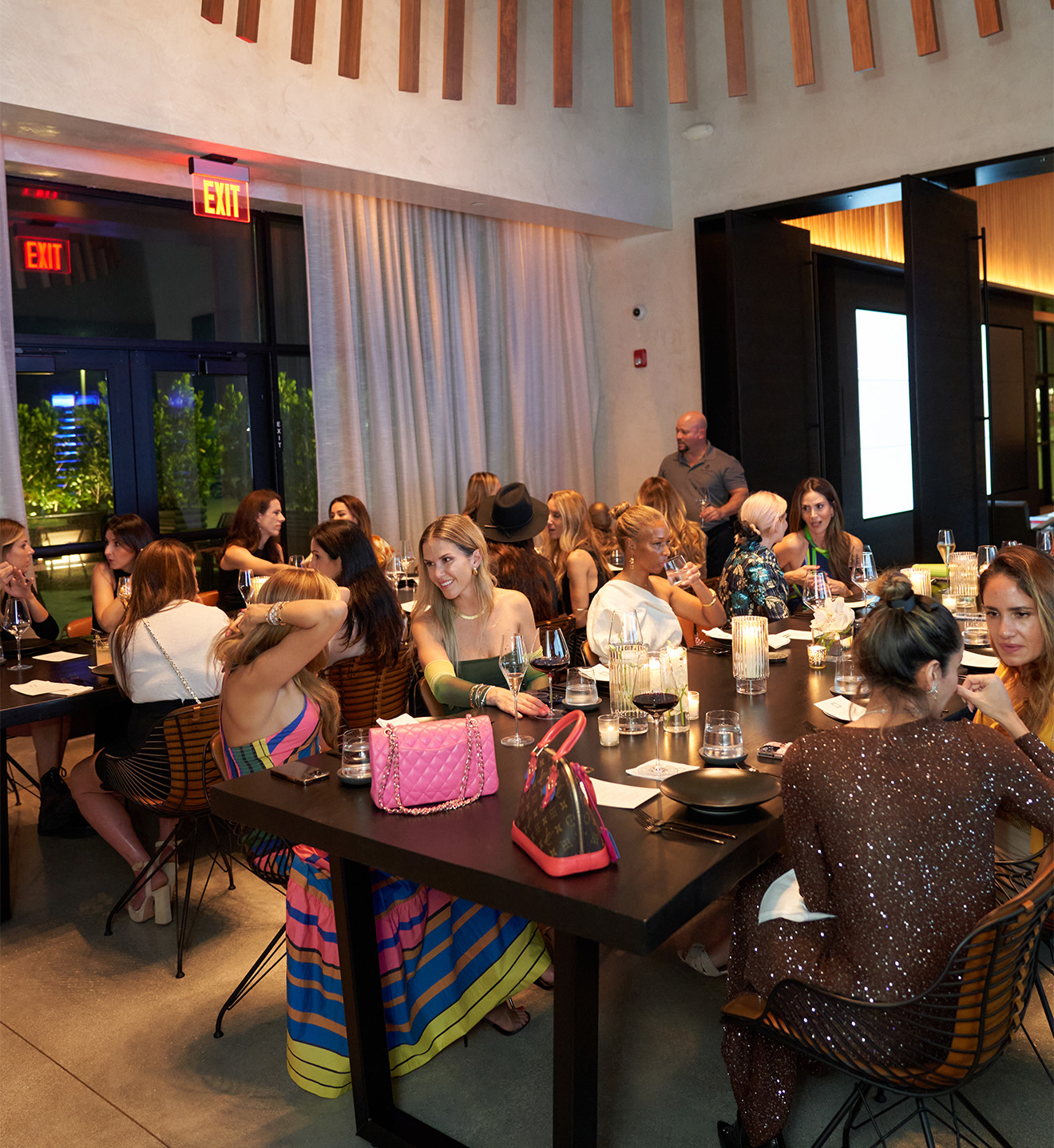 UOVO x Latin American Fashion Summit dinner guests gathered at elegant table for exclusive dining event.