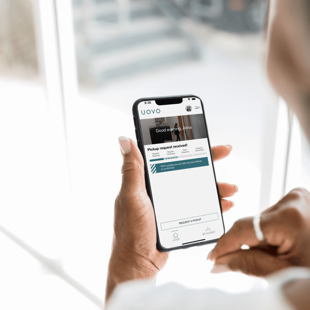 An iPhone with UOVO Fashion's MyCloset app open on the screen.