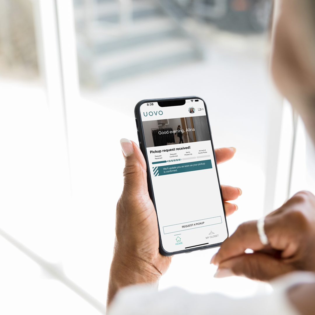 An iPhone with UOVO Fashion's MyCloset app open on the screen.