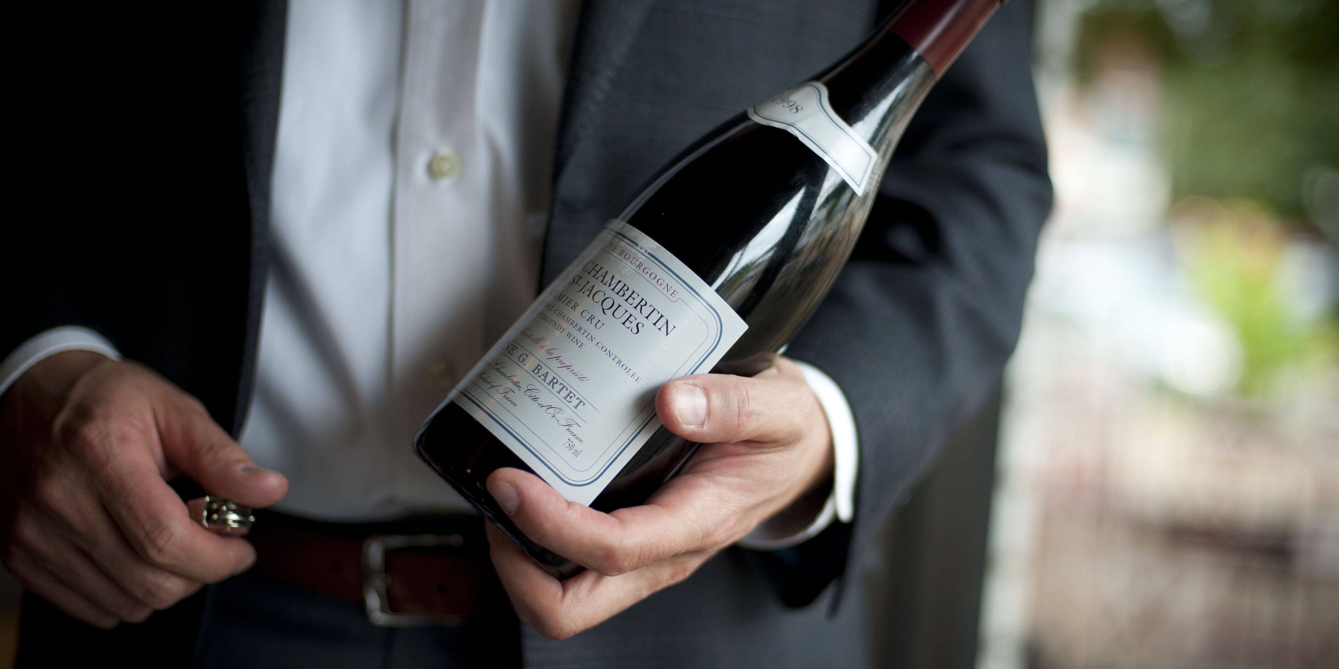 Person Holding Bottle of Red Wine