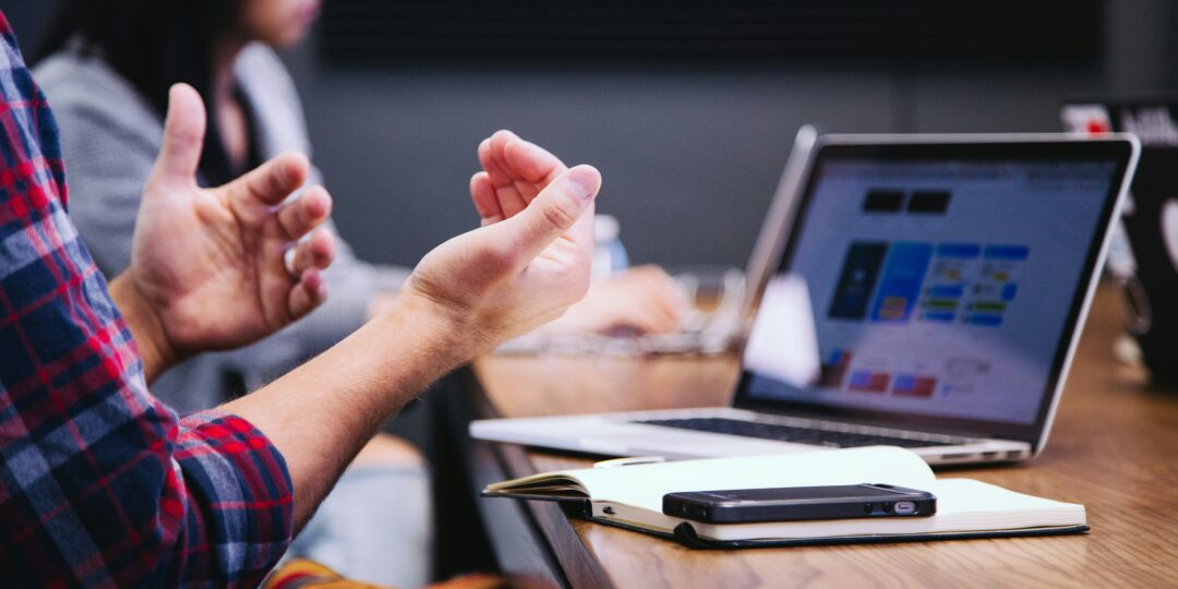 Person Talking in a Meeting in Front of Computer