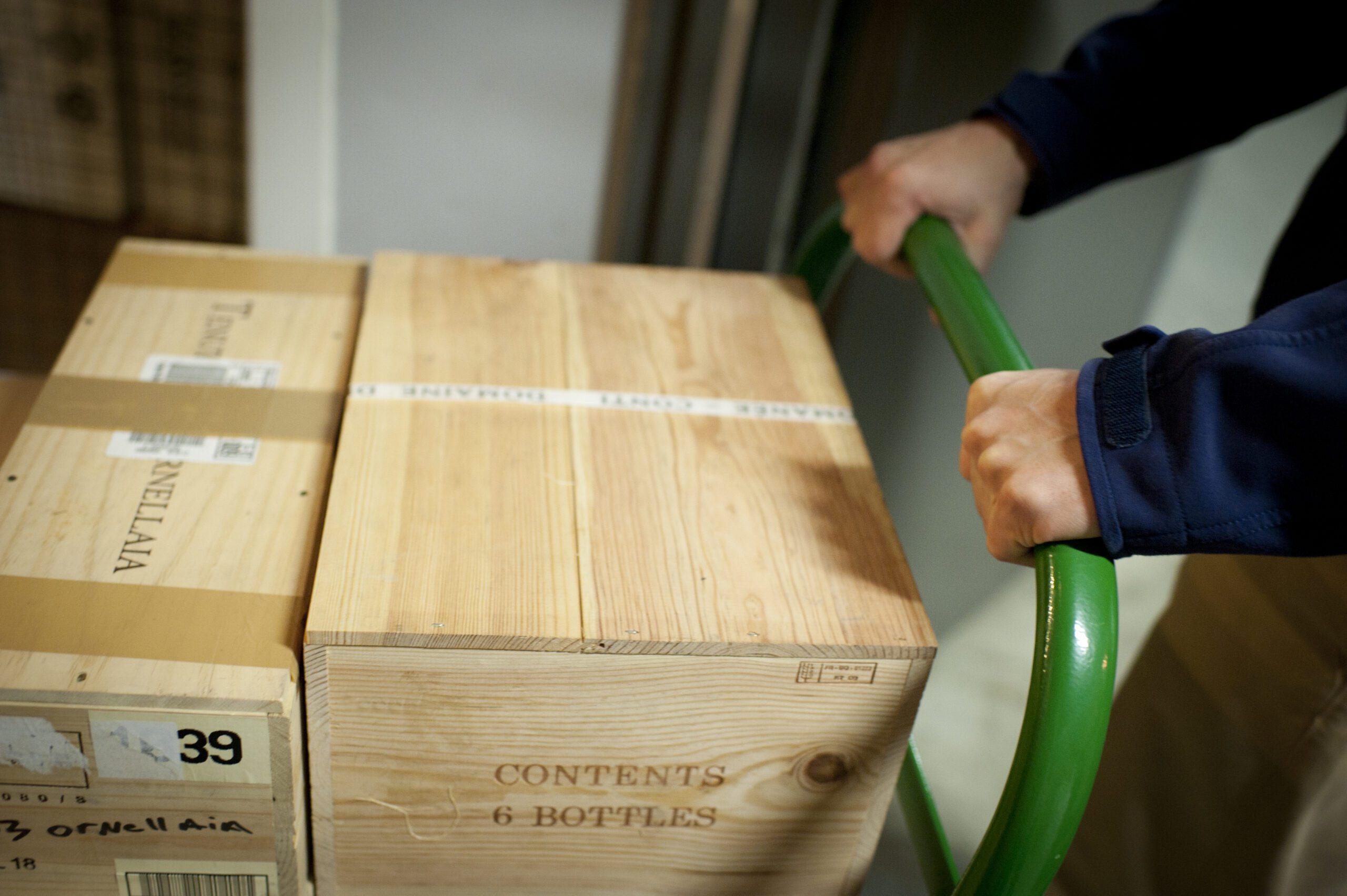UOVO Wine's white-glove service carefully transporting wooden wine crates.