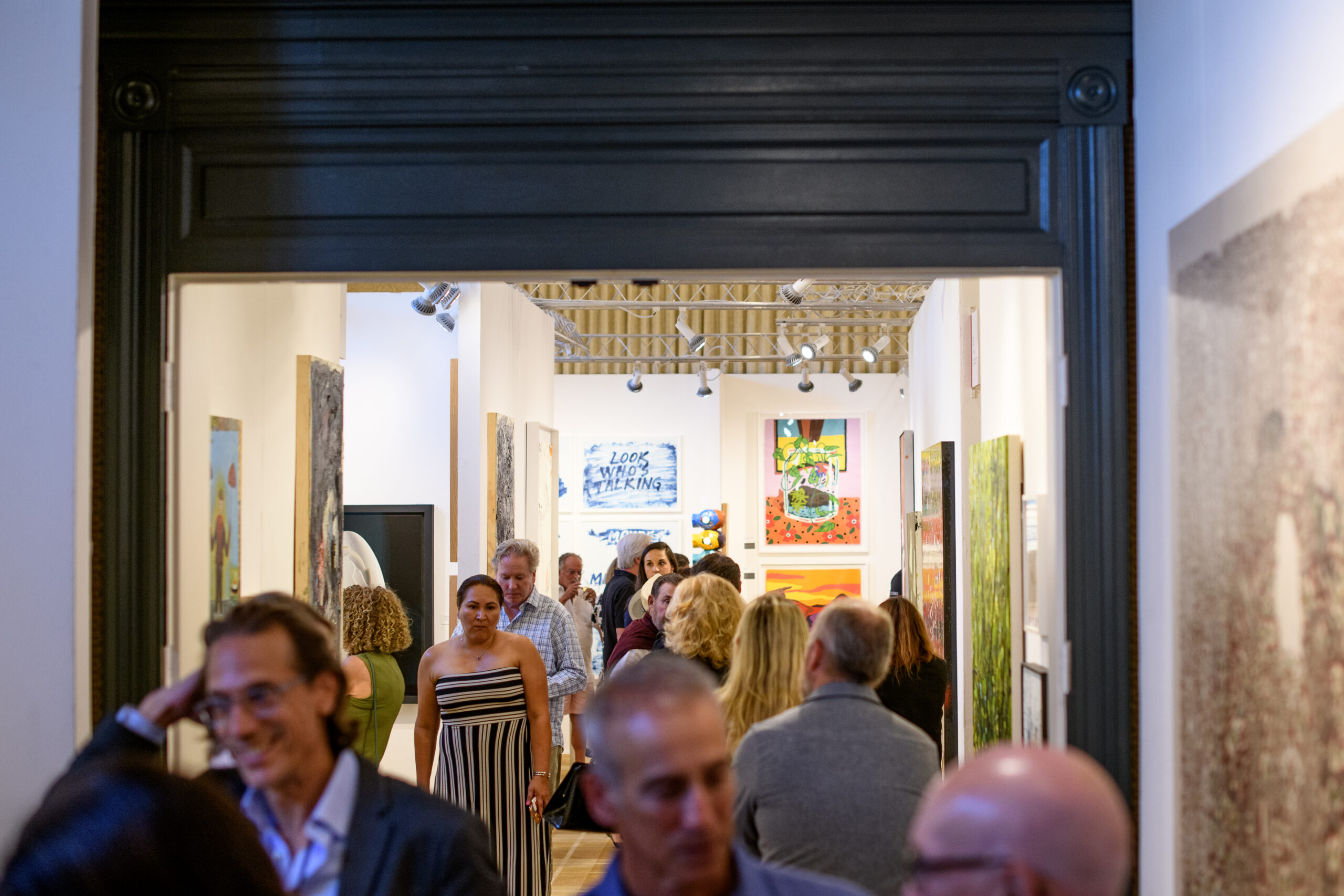 Guests browsing artwork at Aspen Art Fair's inaugural edition in Hotel Jerome's gallery spaces.
