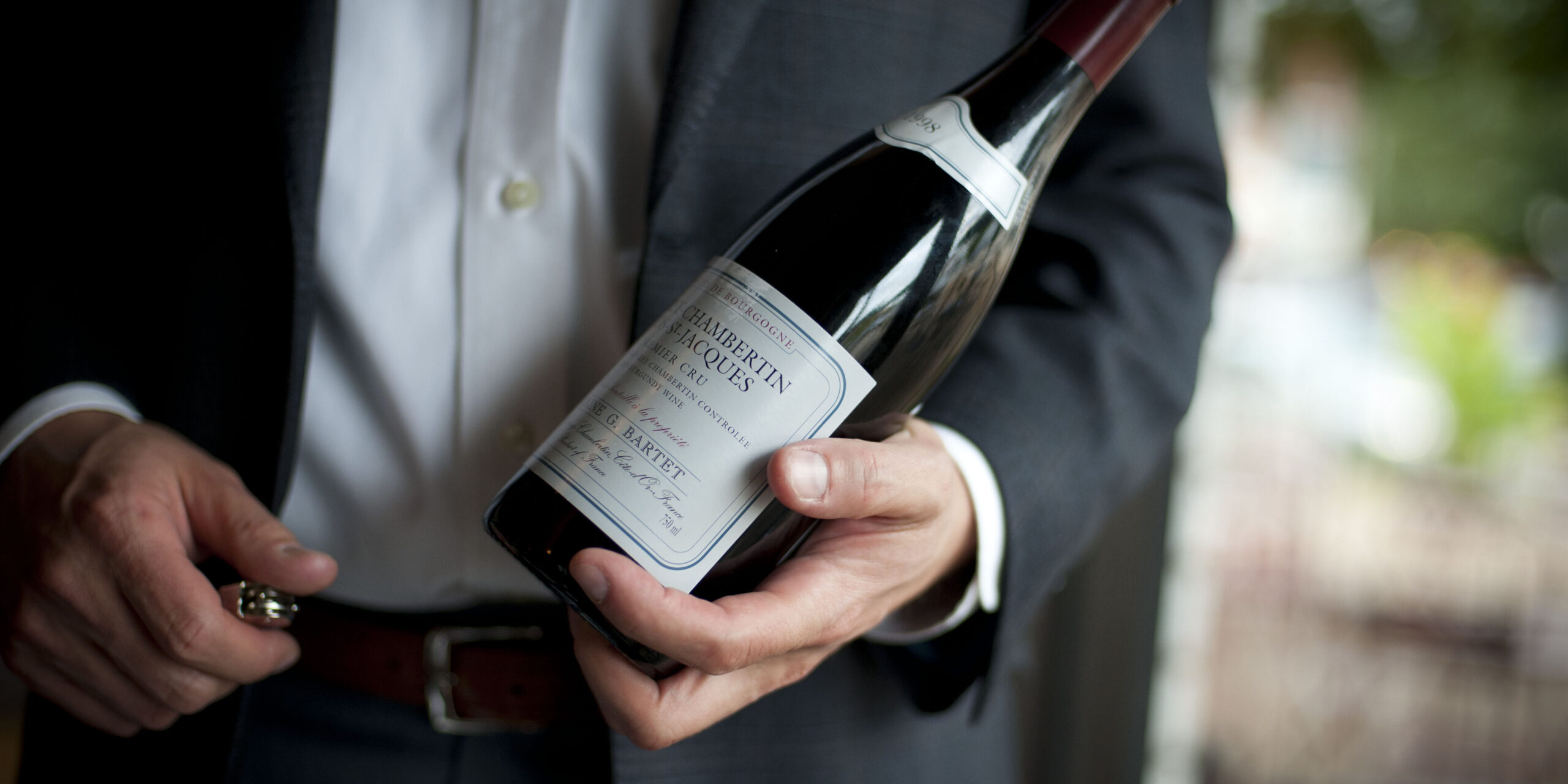 Collector holding a bottle of wine.